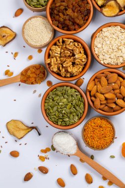 Sağlıklı vejetaryen gıda konsepti. Beyaz arka planda kurutulmuş meyve, fındık ve tohum çeşitleri. Üst görünüm.