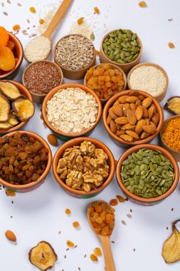 Sağlıklı vejetaryen gıda konsepti. Beyaz arka planda kurutulmuş meyve, fındık ve tohum çeşitleri. Üst görünüm.