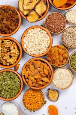 Sağlıklı vejetaryen gıda konsepti. Beyaz arka planda kurutulmuş meyve, fındık ve tohum çeşitleri. Üst görünüm.