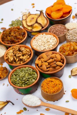 Sağlıklı vejetaryen gıda konsepti. Beyaz arka planda kurutulmuş meyve, fındık ve tohum çeşitleri. Üst görünüm.