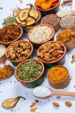 Sağlıklı vejetaryen gıda konsepti. Beyaz arka planda kurutulmuş meyve, fındık ve tohum çeşitleri. Üst görünüm.