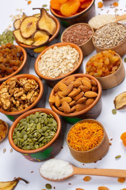 Sağlıklı vejetaryen gıda konsepti. Beyaz arka planda kurutulmuş meyve, fındık ve tohum çeşitleri. Üst görünüm.