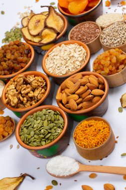 Sağlıklı vejetaryen gıda konsepti. Beyaz arka planda kurutulmuş meyve, fındık ve tohum çeşitleri. Üst görünüm.