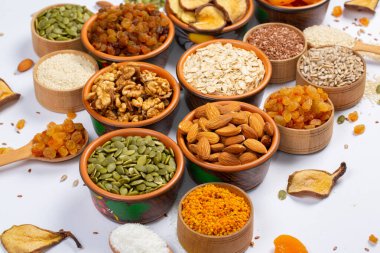 Sağlıklı vejetaryen gıda konsepti. Beyaz arka planda kurutulmuş meyve, fındık ve tohum çeşitleri. Üst görünüm.