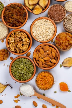 Sağlıklı vejetaryen gıda konsepti. Beyaz arka planda kurutulmuş meyve, fındık ve tohum çeşitleri. Üst görünüm.