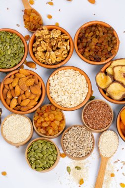 Sağlıklı vejetaryen gıda konsepti. Beyaz arka planda kurutulmuş meyve, fındık ve tohum çeşitleri. Üst görünüm.