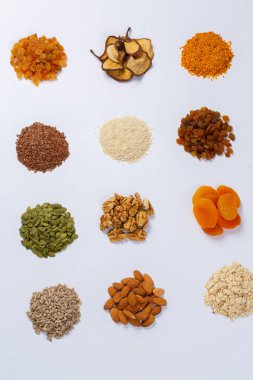 Sağlıklı vejetaryen gıda konsepti. Beyaz arka planda kurutulmuş meyve, fındık ve tohum çeşitleri. Üst görünüm.