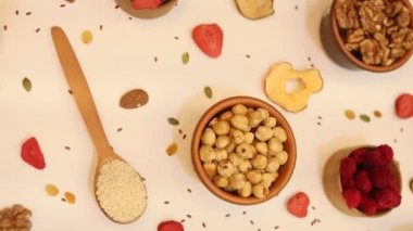 Sağlıklı vejetaryen gıda konsepti. Beyaz arka planda kurutulmuş meyve, fındık ve tohum çeşitleri. Üst görünüm.