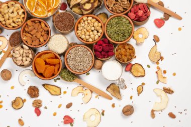 Sağlıklı vejetaryen gıda konsepti. Beyaz arka planda kurutulmuş meyve, fındık ve tohum çeşitleri. Üst görünüm.