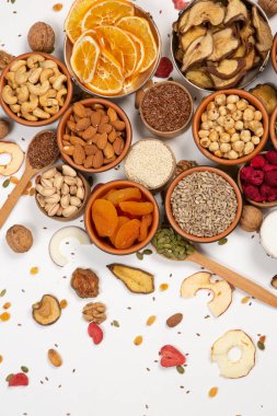 Sağlıklı vejetaryen gıda konsepti. Beyaz arka planda kurutulmuş meyve, fındık ve tohum çeşitleri. Üst görünüm.