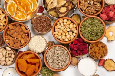 Sağlıklı vejetaryen gıda konsepti. Beyaz arka planda kurutulmuş meyve, fındık ve tohum çeşitleri. Üst görünüm.