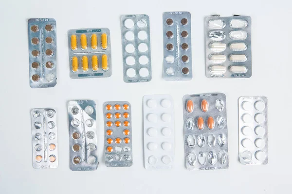 Pills in blister pack on white background. Tablets and capsules in blister packs. Top view, copy space.