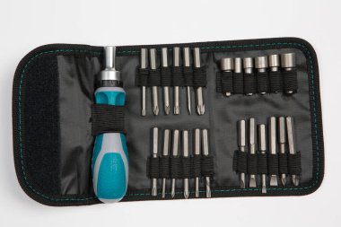 Beyaz arka plandaki bir çantada tamir için gerekli aletler. Çeşitli iş ya da inşaat aletleri. Anahtarlar, pense, tornavida. Üst görünüm