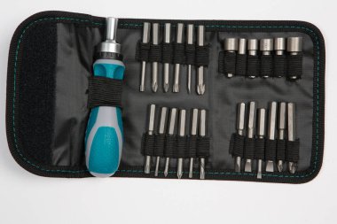 Beyaz arka plandaki bir çantada tamir için gerekli aletler. Çeşitli iş ya da inşaat aletleri. Anahtarlar, pense, tornavida. Üst görünüm