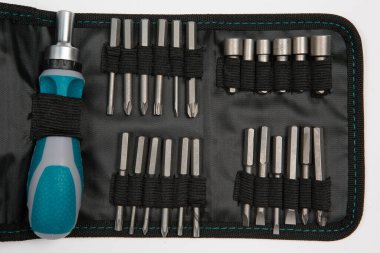 Beyaz arka plandaki bir çantada tamir için gerekli aletler. Çeşitli iş ya da inşaat aletleri. Anahtarlar, pense, tornavida. Üst görünüm