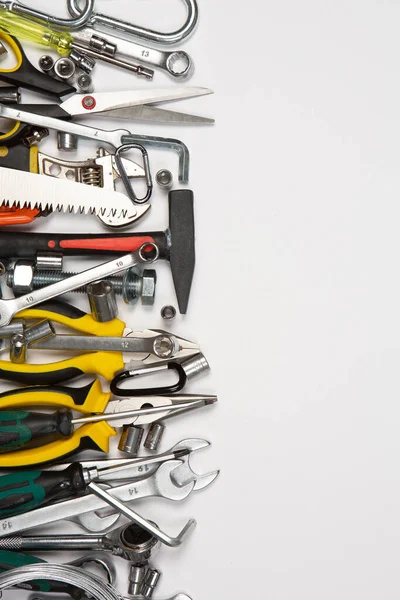 Beyaz arka plandaki bir çantada tamir için gerekli aletler. Çeşitli iş ya da inşaat aletleri. Anahtarlar, pense, tornavida. Üst görünüm