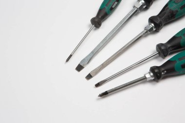 Beyaz arka plandaki bir çantada tamir için gerekli aletler. Çeşitli iş ya da inşaat aletleri. Anahtarlar, pense, tornavida. Üst görünüm