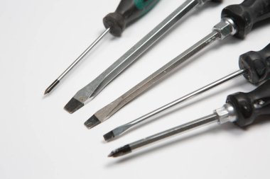 Beyaz arka plandaki bir çantada tamir için gerekli aletler. Çeşitli iş ya da inşaat aletleri. Anahtarlar, pense, tornavida. Üst görünüm