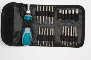 Beyaz arka plandaki bir çantada tamir için gerekli aletler. Çeşitli iş ya da inşaat aletleri. Anahtarlar, pense, tornavida. Üst görünüm