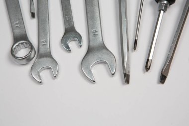 Beyaz arka plandaki bir çantada tamir için gerekli aletler. Çeşitli iş ya da inşaat aletleri. Anahtarlar, pense, tornavida. Üst görünüm