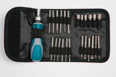 Beyaz arka plandaki bir çantada tamir için gerekli aletler. Çeşitli iş ya da inşaat aletleri. Anahtarlar, pense, tornavida. Üst görünüm