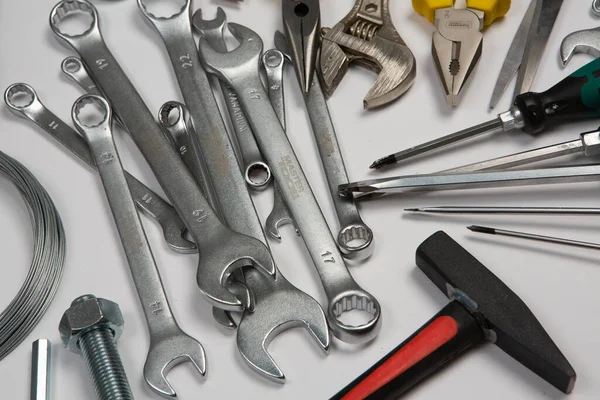 Beyaz arka plandaki bir çantada tamir için gerekli aletler. Çeşitli iş ya da inşaat aletleri. Anahtarlar, pense, tornavida. Üst görünüm