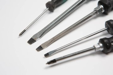 Beyaz arka plandaki bir çantada tamir için gerekli aletler. Çeşitli iş ya da inşaat aletleri. Anahtarlar, pense, tornavida. Üst görünüm