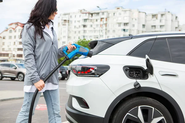 Ev充電ステーションで電気自動車を給油する若いビジネス女性 環境に優しい車の概念 電気自動車の概念 緑の旅 — ストック写真
