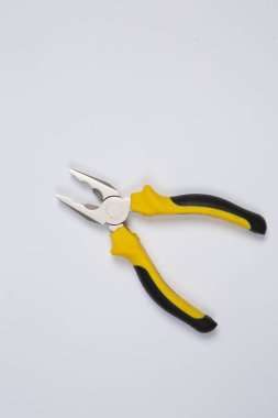 Beyaz arka plandaki bir çantada tamir için gerekli aletler. Çeşitli iş ya da inşaat aletleri. Anahtarlar, pense, tornavida. Üst görünüm