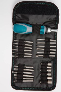 Beyaz arka plandaki bir çantada tamir için gerekli aletler. Çeşitli iş ya da inşaat aletleri. Anahtarlar, pense, tornavida. Üst görünüm