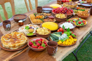Kamp yaparken ızgara et, polenta ve sebze tabağı ile ev yapımı Romen yemekleri. Ahşap masanın üzerinde romantik Moldova yemekleri.