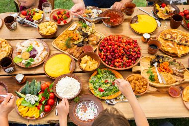 Kamp yaparken ızgara et, polenta ve sebze tabağı ile ev yapımı Romen yemekleri. Ahşap masanın üzerinde romantik Moldova yemekleri.