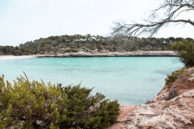 Güzel gün batımı plaj manzarası, egzotik tropik ada doğası, mavi deniz suyu, okyanus dalgaları, renkli kırmızı gökyüzü, Mallorca, İspanya 'da yaz tatili