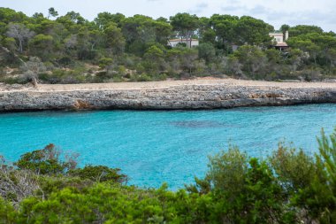 Güzel gün batımı plaj manzarası, egzotik tropik ada doğası, mavi deniz suyu, okyanus dalgaları, renkli kırmızı gökyüzü, Mallorca, İspanya 'da yaz tatili