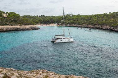 Güzel gün batımı plaj manzarası, egzotik tropik ada doğası, mavi deniz suyu, okyanus dalgaları, renkli kırmızı gökyüzü, Mallorca, İspanya 'da yaz tatili