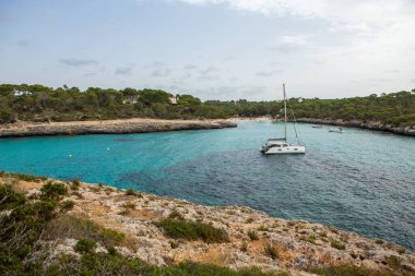 Güzel gün batımı plaj manzarası, egzotik tropik ada doğası, mavi deniz suyu, okyanus dalgaları, renkli kırmızı gökyüzü, Mallorca, İspanya 'da yaz tatili