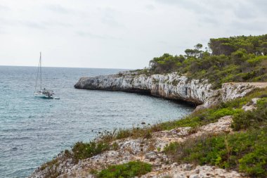 Güzel gün batımı plaj manzarası, egzotik tropik ada doğası, mavi deniz suyu, okyanus dalgaları, renkli kırmızı gökyüzü, Mallorca, İspanya 'da yaz tatili