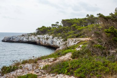 Güzel gün batımı plaj manzarası, egzotik tropik ada doğası, mavi deniz suyu, okyanus dalgaları, renkli kırmızı gökyüzü, Mallorca, İspanya 'da yaz tatili