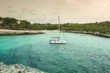 Güzel gün batımı plaj manzarası, egzotik tropik ada doğası, mavi deniz suyu, okyanus dalgaları, renkli kırmızı gökyüzü, Mallorca, İspanya 'da yaz tatili