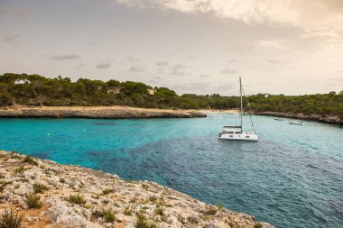 Güzel gün batımı plaj manzarası, egzotik tropik ada doğası, mavi deniz suyu, okyanus dalgaları, renkli kırmızı gökyüzü, Mallorca, İspanya 'da yaz tatili