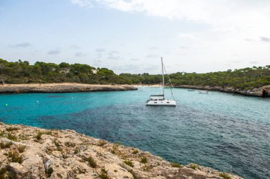 Güzel gün batımı plaj manzarası, egzotik tropik ada doğası, mavi deniz suyu, okyanus dalgaları, renkli kırmızı gökyüzü, Mallorca, İspanya 'da yaz tatili
