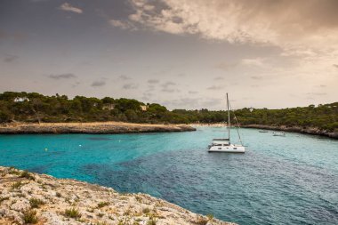 Güzel gün batımı plaj manzarası, egzotik tropik ada doğası, mavi deniz suyu, okyanus dalgaları, renkli kırmızı gökyüzü, Mallorca, İspanya 'da yaz tatili