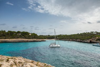 Güzel gün batımı plaj manzarası, egzotik tropik ada doğası, mavi deniz suyu, okyanus dalgaları, renkli kırmızı gökyüzü, Mallorca, İspanya 'da yaz tatili