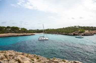 Güzel gün batımı plaj manzarası, egzotik tropik ada doğası, mavi deniz suyu, okyanus dalgaları, renkli kırmızı gökyüzü, Mallorca, İspanya 'da yaz tatili