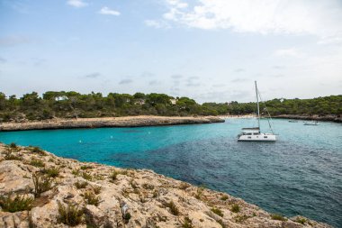 Güzel gün batımı plaj manzarası, egzotik tropik ada doğası, mavi deniz suyu, okyanus dalgaları, renkli kırmızı gökyüzü, Mallorca, İspanya 'da yaz tatili