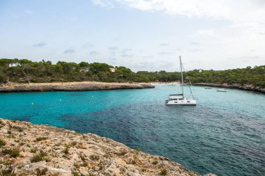 Güzel gün batımı plaj manzarası, egzotik tropik ada doğası, mavi deniz suyu, okyanus dalgaları, renkli kırmızı gökyüzü, Mallorca, İspanya 'da yaz tatili