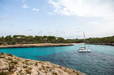 Güzel gün batımı plaj manzarası, egzotik tropik ada doğası, mavi deniz suyu, okyanus dalgaları, renkli kırmızı gökyüzü, Mallorca, İspanya 'da yaz tatili