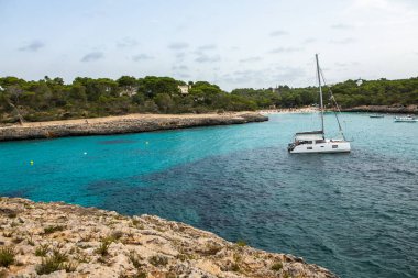 Güzel gün batımı plaj manzarası, egzotik tropik ada doğası, mavi deniz suyu, okyanus dalgaları, renkli kırmızı gökyüzü, Mallorca, İspanya 'da yaz tatili