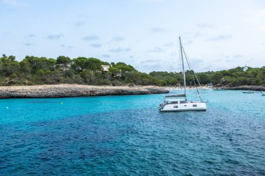 Güzel gün batımı plaj manzarası, egzotik tropik ada doğası, mavi deniz suyu, okyanus dalgaları, renkli kırmızı gökyüzü, Mallorca, İspanya 'da yaz tatili