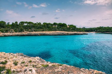 Güzel gün batımı plaj manzarası, egzotik tropik ada doğası, mavi deniz suyu, okyanus dalgaları, renkli kırmızı gökyüzü, Mallorca, İspanya 'da yaz tatili